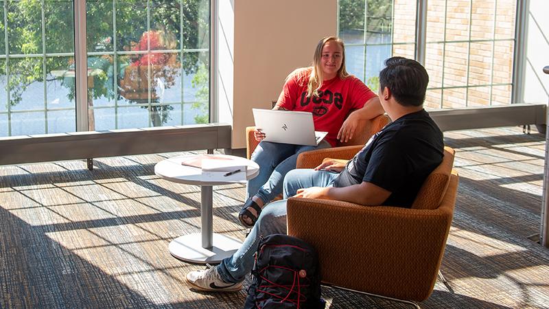 Two students talking in Eastman lounge